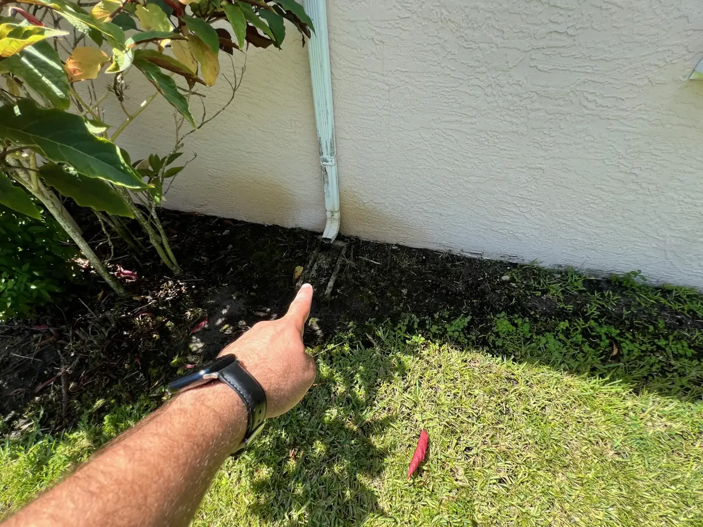 Downspout draining right at the foundation, pointed out during an inspection