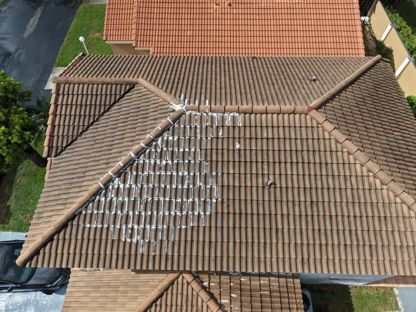 Drone photo showing patched tiles on a barrel tile roof